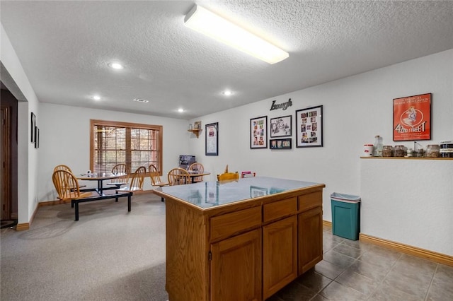 kitchen featuring carpet flooring, a center island, and a textured ceiling