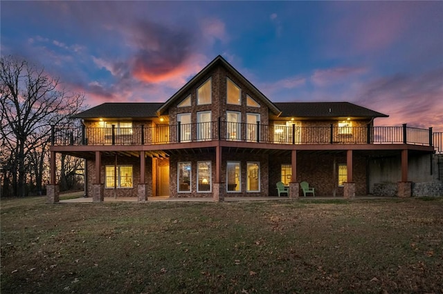 back house at dusk with a deck and a yard