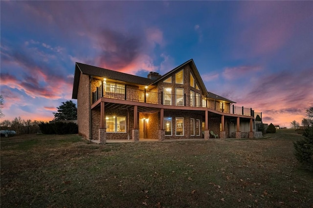 back house at dusk with a lawn and a wooden deck