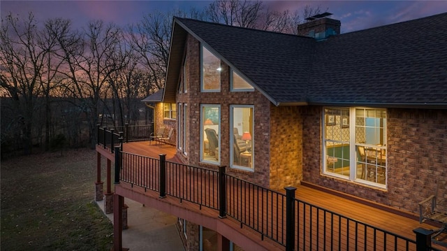 property exterior at dusk featuring a wooden deck