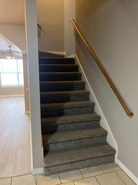 staircase with tile patterned floors and ceiling fan