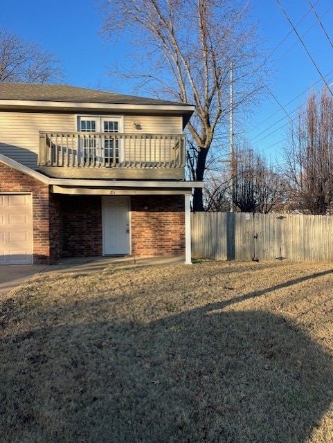 front facade with a garage and a balcony