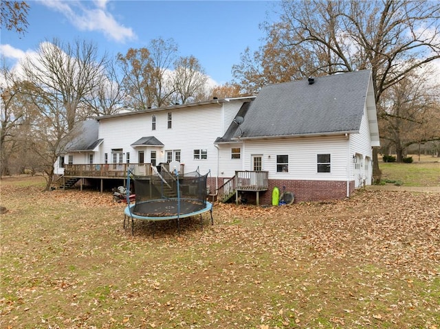 back of property featuring a trampoline, a deck, and a garage