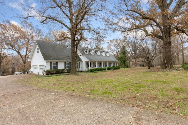 cape cod house featuring a garage and a front lawn