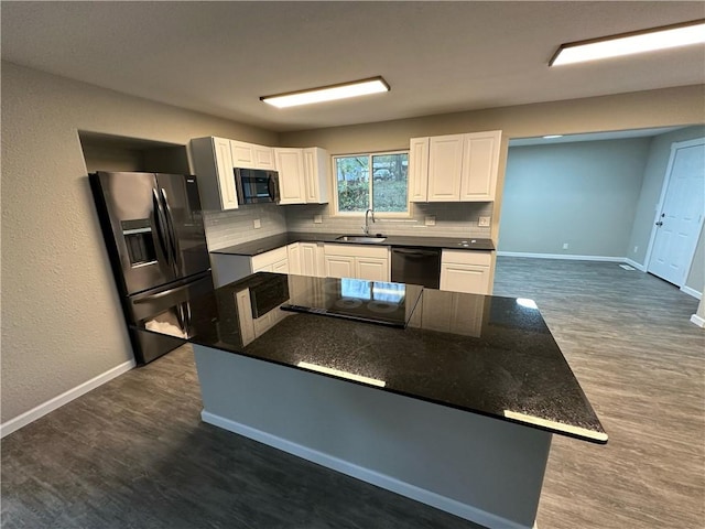 kitchen featuring tasteful backsplash, dark wood-type flooring, sink, black appliances, and white cabinets