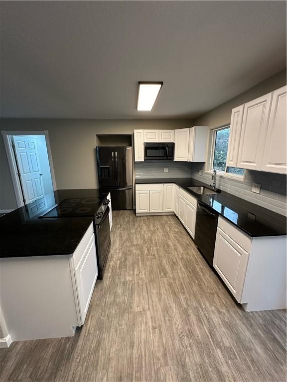 kitchen with white cabinets, light wood-type flooring, sink, and black appliances