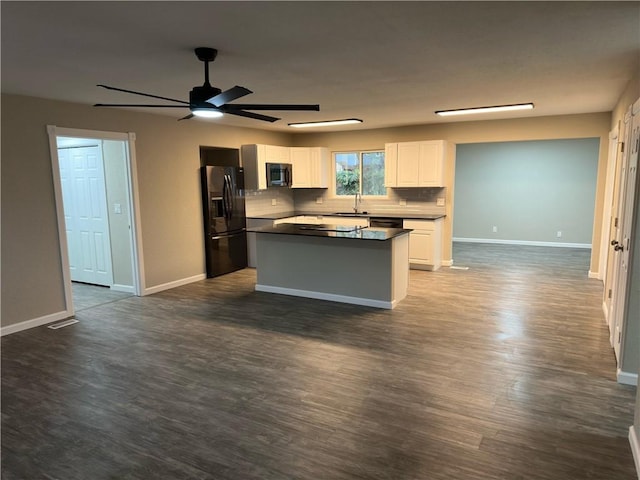 kitchen with black refrigerator with ice dispenser, white cabinets, sink, tasteful backsplash, and dark hardwood / wood-style flooring