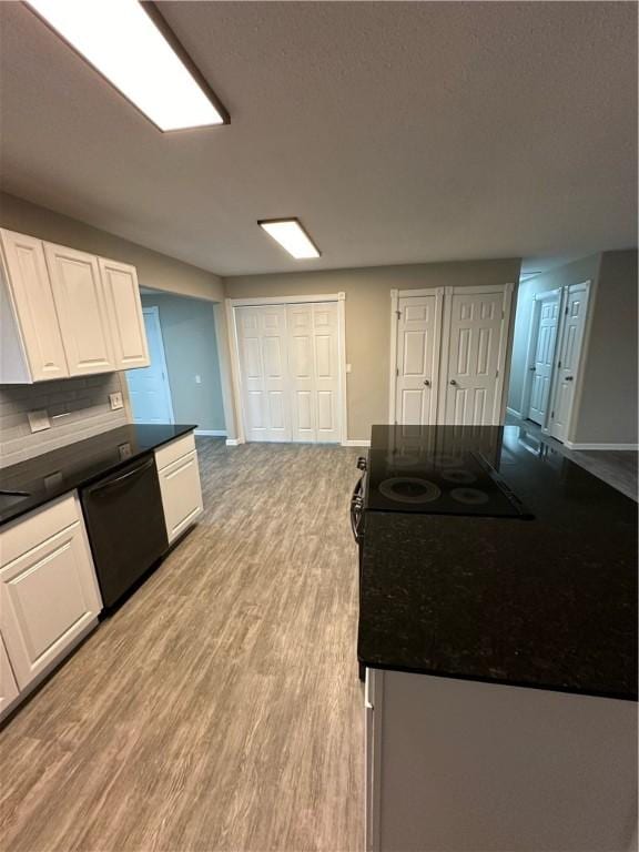 kitchen featuring black appliances, decorative backsplash, white cabinets, and light hardwood / wood-style flooring