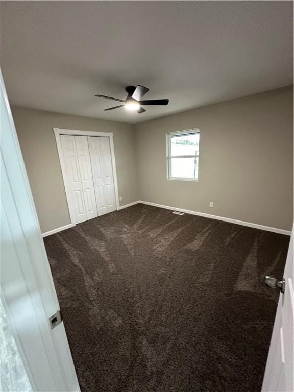 unfurnished bedroom with carpet flooring, ceiling fan, and a closet