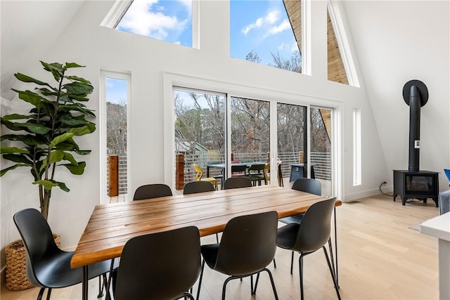 dining space with a wood stove and light wood-style floors