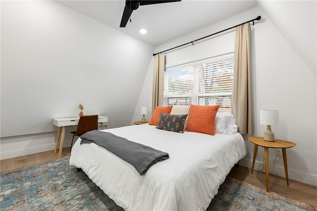 bedroom with vaulted ceiling, ceiling fan, baseboards, and wood finished floors