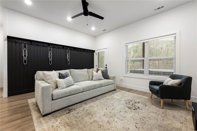 living room with recessed lighting, wood finished floors, visible vents, and baseboards