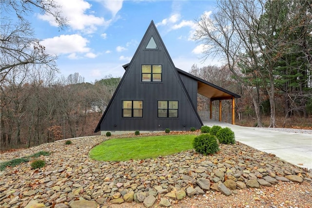 view of front of house with a front lawn, board and batten siding, and driveway