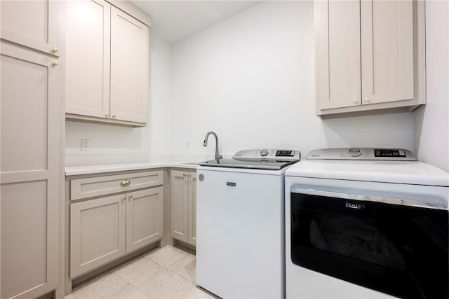 washroom with washing machine and dryer, cabinet space, marble finish floor, and a sink