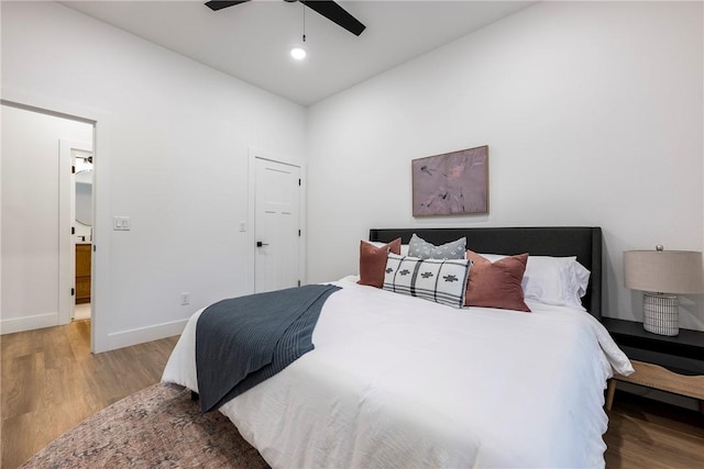 bedroom featuring ceiling fan, light hardwood / wood-style floors, and lofted ceiling