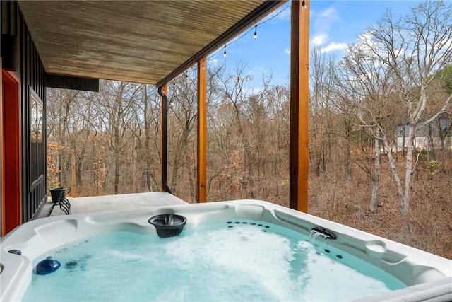 exterior space with wood ceiling and a hot tub