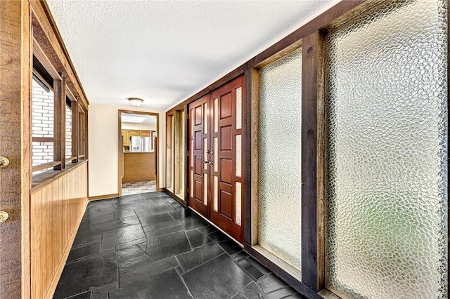 hallway with a textured ceiling