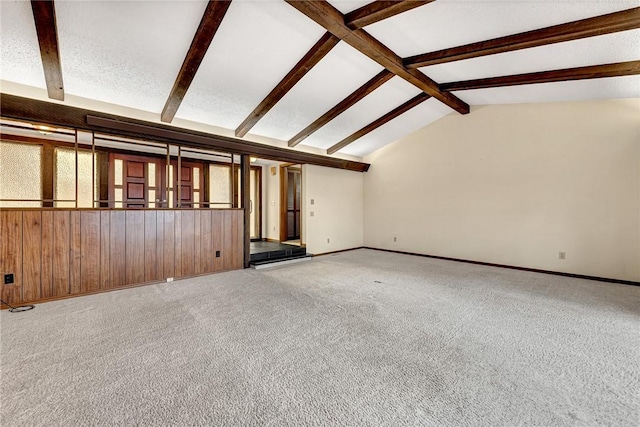 unfurnished living room with carpet floors and lofted ceiling with beams