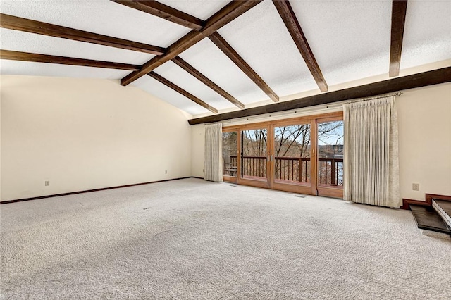 unfurnished living room with carpet flooring and vaulted ceiling with beams