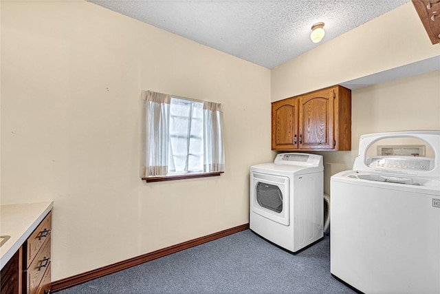 clothes washing area featuring washer and clothes dryer, cabinets, carpet floors, and a textured ceiling