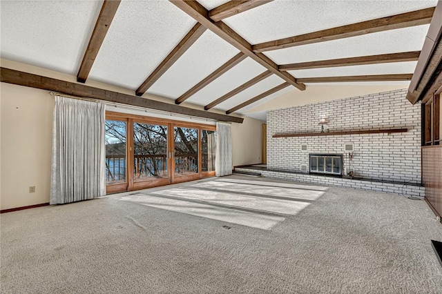 unfurnished living room with a brick fireplace, carpet flooring, vaulted ceiling with beams, a textured ceiling, and brick wall