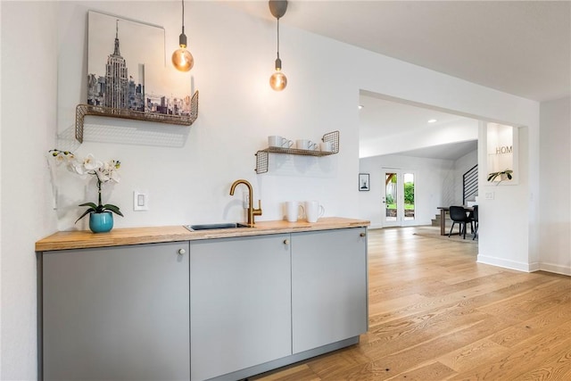 kitchen featuring french doors, light hardwood / wood-style floors, hanging light fixtures, and sink