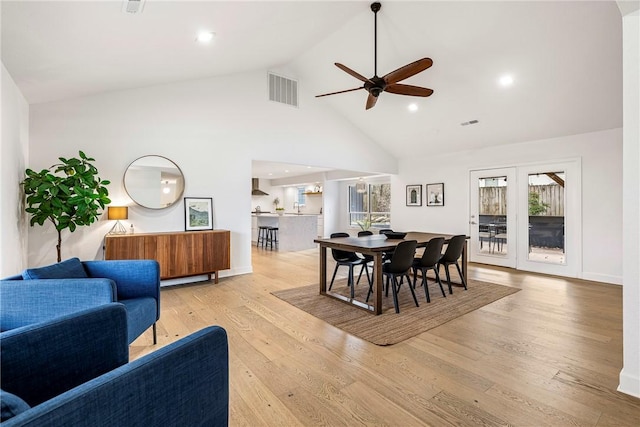 dining area featuring ceiling fan, light hardwood / wood-style flooring, and high vaulted ceiling