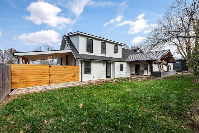 rear view of house with a carport and a yard