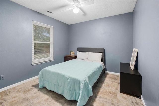 bedroom featuring ceiling fan and a textured ceiling