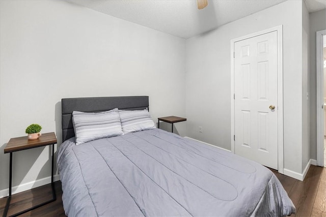 bedroom featuring ceiling fan, dark hardwood / wood-style flooring, and a textured ceiling