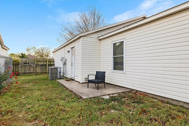 back of house with central AC unit, a patio area, and a yard