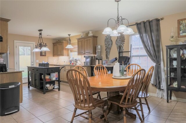 tiled dining space featuring an inviting chandelier and sink