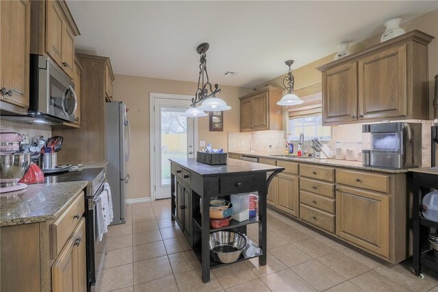 kitchen with stainless steel appliances, a center island, light tile patterned flooring, and sink