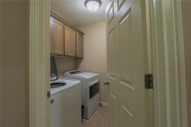 washroom featuring cabinets, separate washer and dryer, and light tile patterned floors