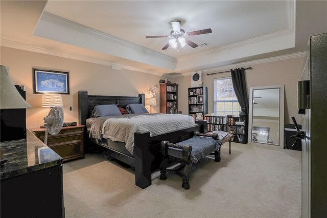 carpeted bedroom featuring ceiling fan, crown molding, and a tray ceiling