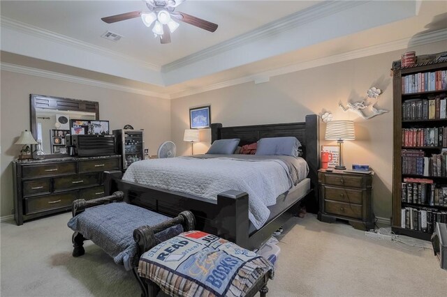 bedroom with ceiling fan, light colored carpet, crown molding, and a tray ceiling