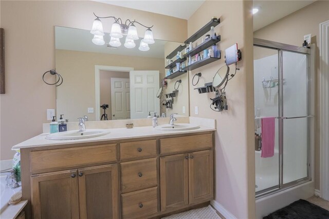 bathroom featuring a shower with door and vanity