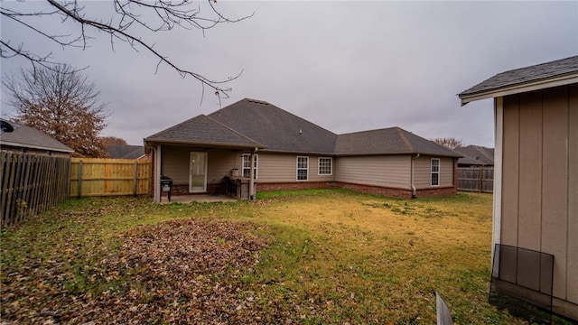 rear view of house with a patio area and a lawn