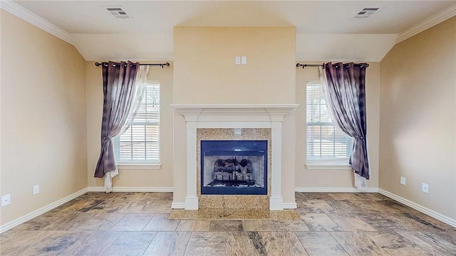 unfurnished living room featuring baseboards, healthy amount of natural light, lofted ceiling, a glass covered fireplace, and ornamental molding