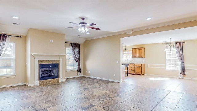 unfurnished living room featuring ceiling fan, plenty of natural light, a fireplace, and recessed lighting