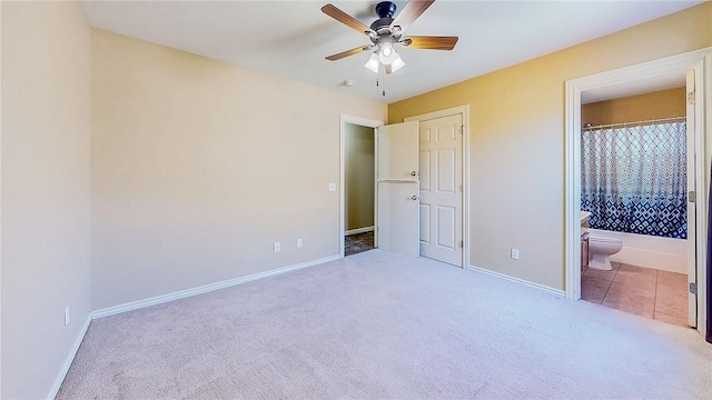 unfurnished bedroom with carpet flooring, baseboards, ensuite bathroom, and ceiling fan