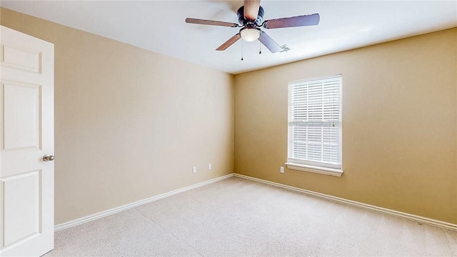 carpeted empty room with a ceiling fan and baseboards