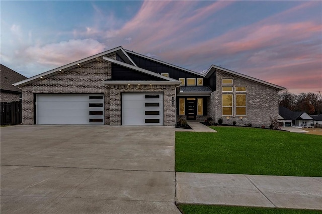 view of front of home with a garage and a lawn