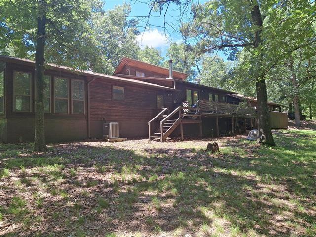 rear view of property featuring a wooden deck and central AC