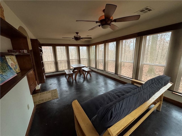 sunroom / solarium with ceiling fan and a baseboard heating unit