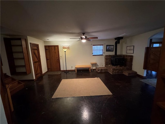 living room featuring ceiling fan and a wood stove