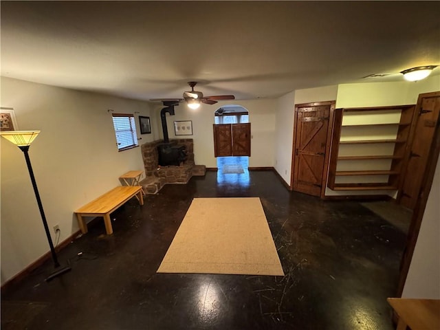 living room featuring a wood stove and ceiling fan