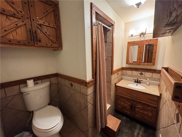 bathroom featuring vanity, a shower with shower curtain, tile walls, and toilet