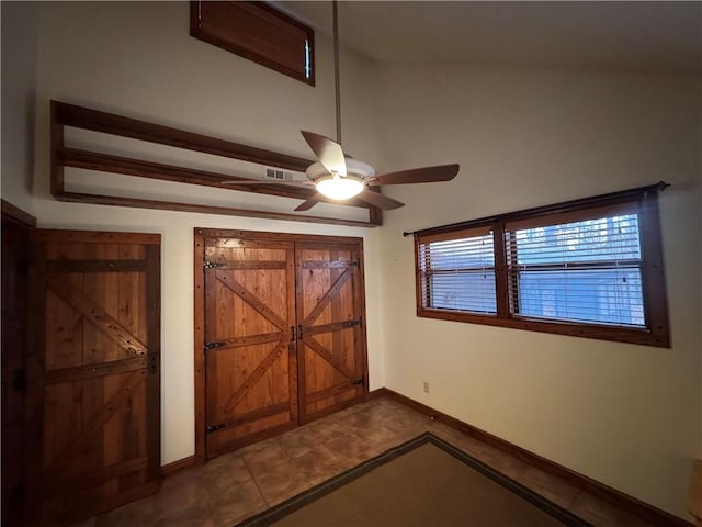 interior space featuring tile patterned floors, ceiling fan, and lofted ceiling