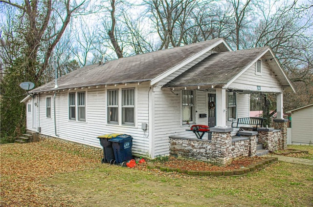 view of front of home with covered porch and a front lawn